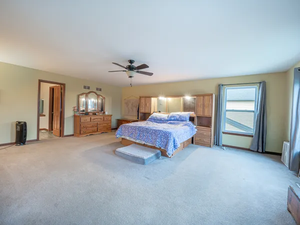 a spacious bedroom with a bed and a cabinets