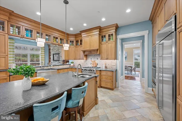 a kitchen with stainless steel appliances granite countertop a sink a stove and a refrigerator