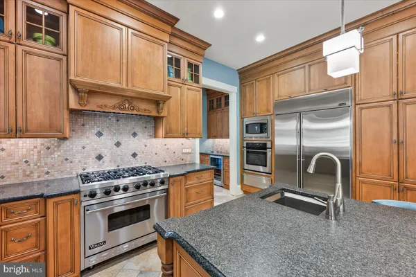 a kitchen with stainless steel appliances granite countertop a stove and a refrigerator
