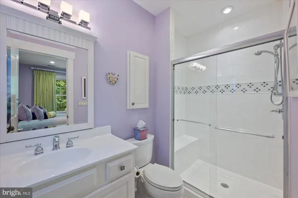 a bathroom with a sink a toilet a mirror and shower