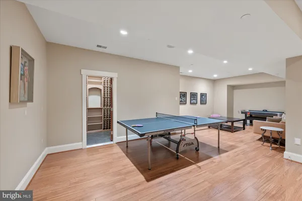 a living room with furniture pool table and a wooden floor
