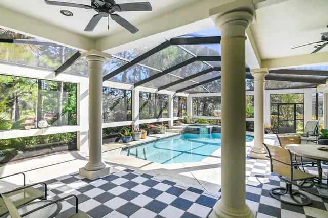 a living room with furniture a flat screen tv and a floor to ceiling window