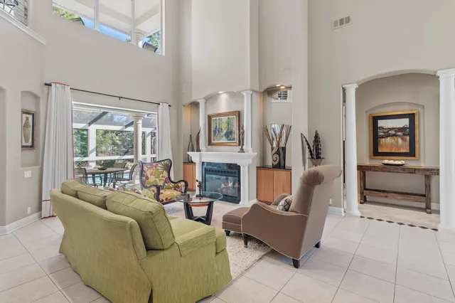 a living room with furniture a fireplace and a large window