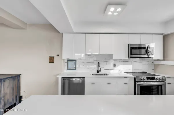a kitchen with counter top a sink and appliances