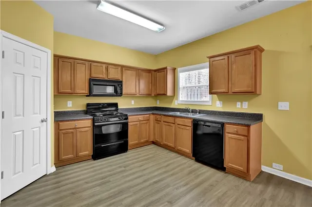 a kitchen with stainless steel appliances granite countertop a stove a sink and a microwave