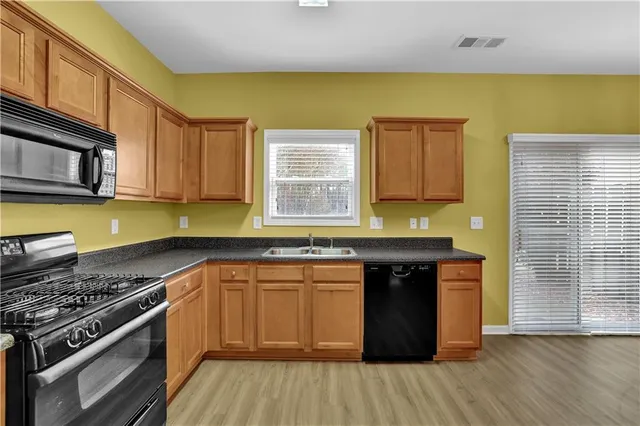 a kitchen with stainless steel appliances granite countertop a stove a sink and a microwave