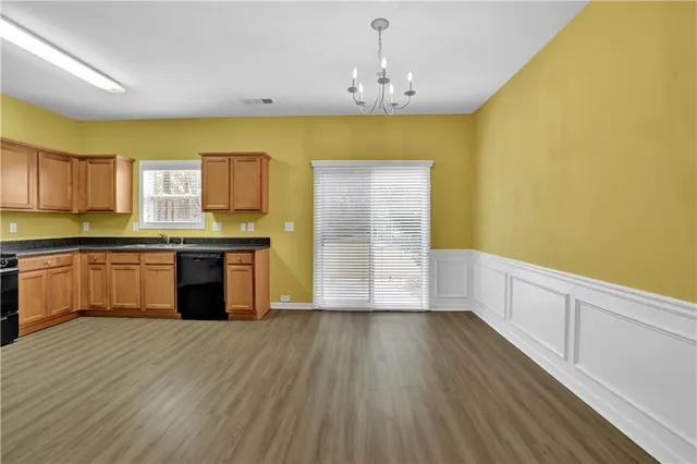 a large kitchen with a sink and wooden floor
