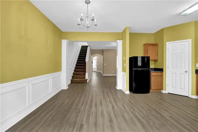 a view of a kitchen with wooden floor and stainless steel appliances