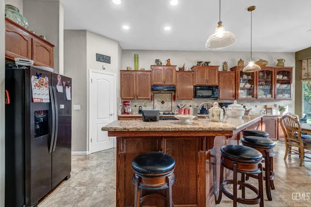 a kitchen with stainless steel appliances granite countertop a sink and a refrigerator