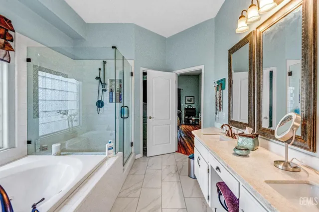 a bathroom with a granite countertop tub sink and mirror