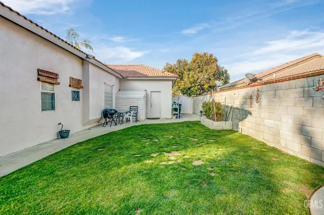 a backyard of a house with table and chairs