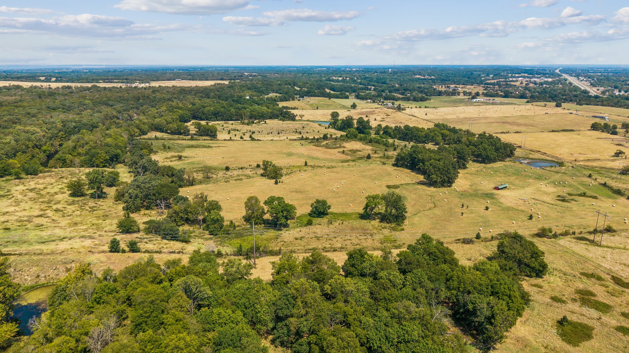 0 East 420 Road Claremore, OK 74017 - Photo 1 of 9 Expansive rural landscape featuring fields, scattered trees, and natural bodies of water