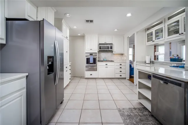 a kitchen with stainless steel appliances a refrigerator sink and cabinets