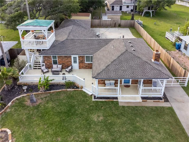 an aerial view of a house with garden space and a patio
