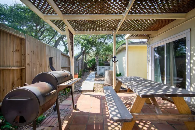 a patio with glass top table and chairs