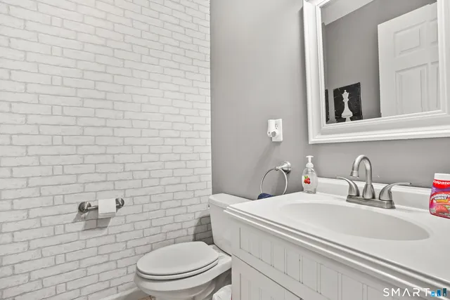 a bathroom with a toilet a sink and mirror