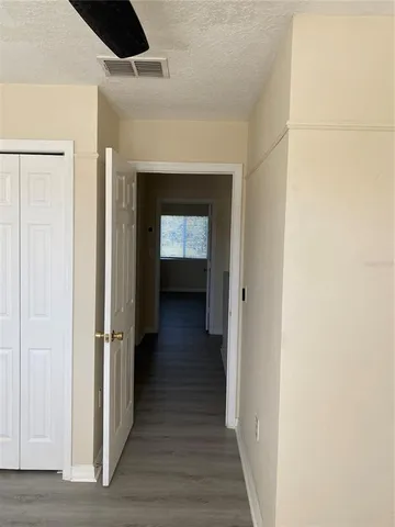 a view of a hallway with wooden floor and closet