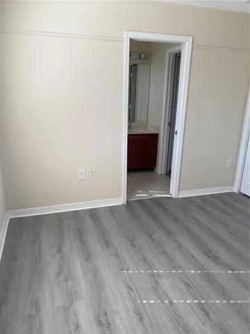 an empty room with wooden floor and closet