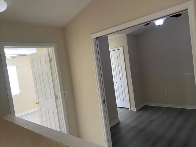 a view of a hallway with wooden floor