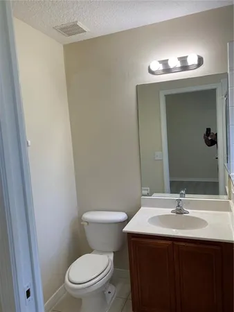 a bathroom with a sink a toilet a mirror and vanity