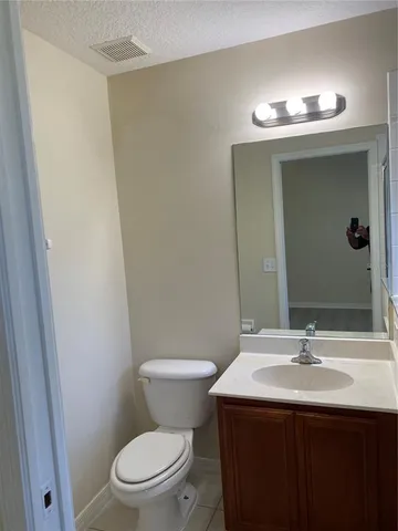 a bathroom with a sink a toilet a mirror and vanity