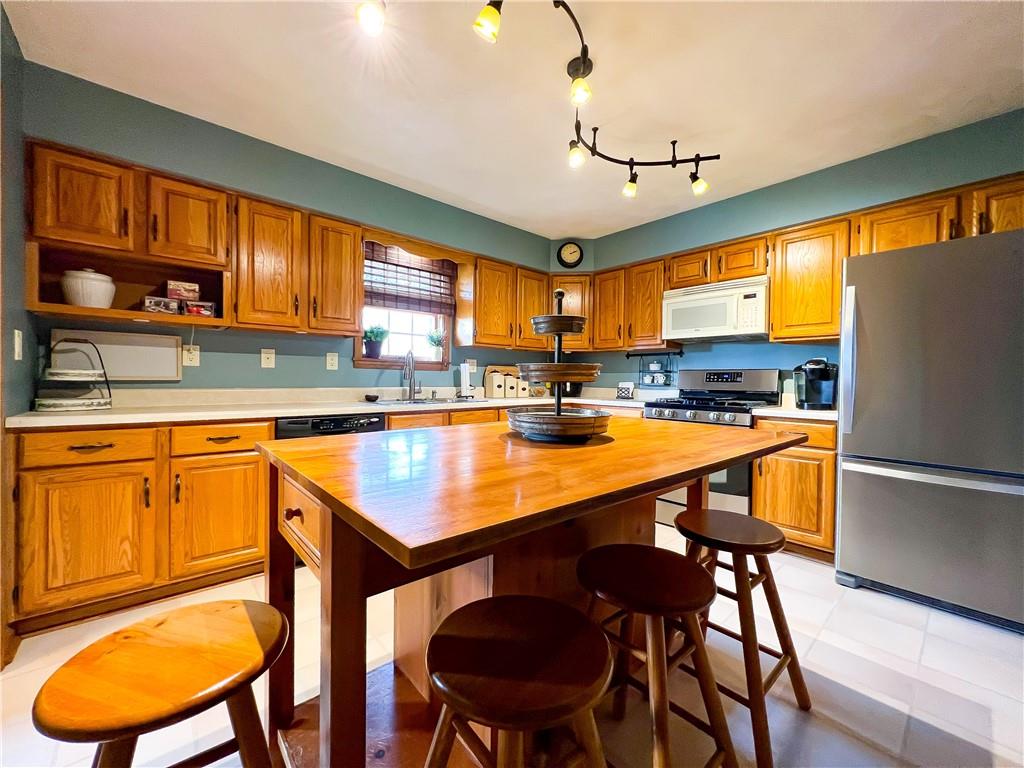 212 Meridian Road Butler, PA 16001 - Photo 7 of 25 a kitchen with stainless steel appliances granite countertop a table chairs sink refrigerator and cabinets