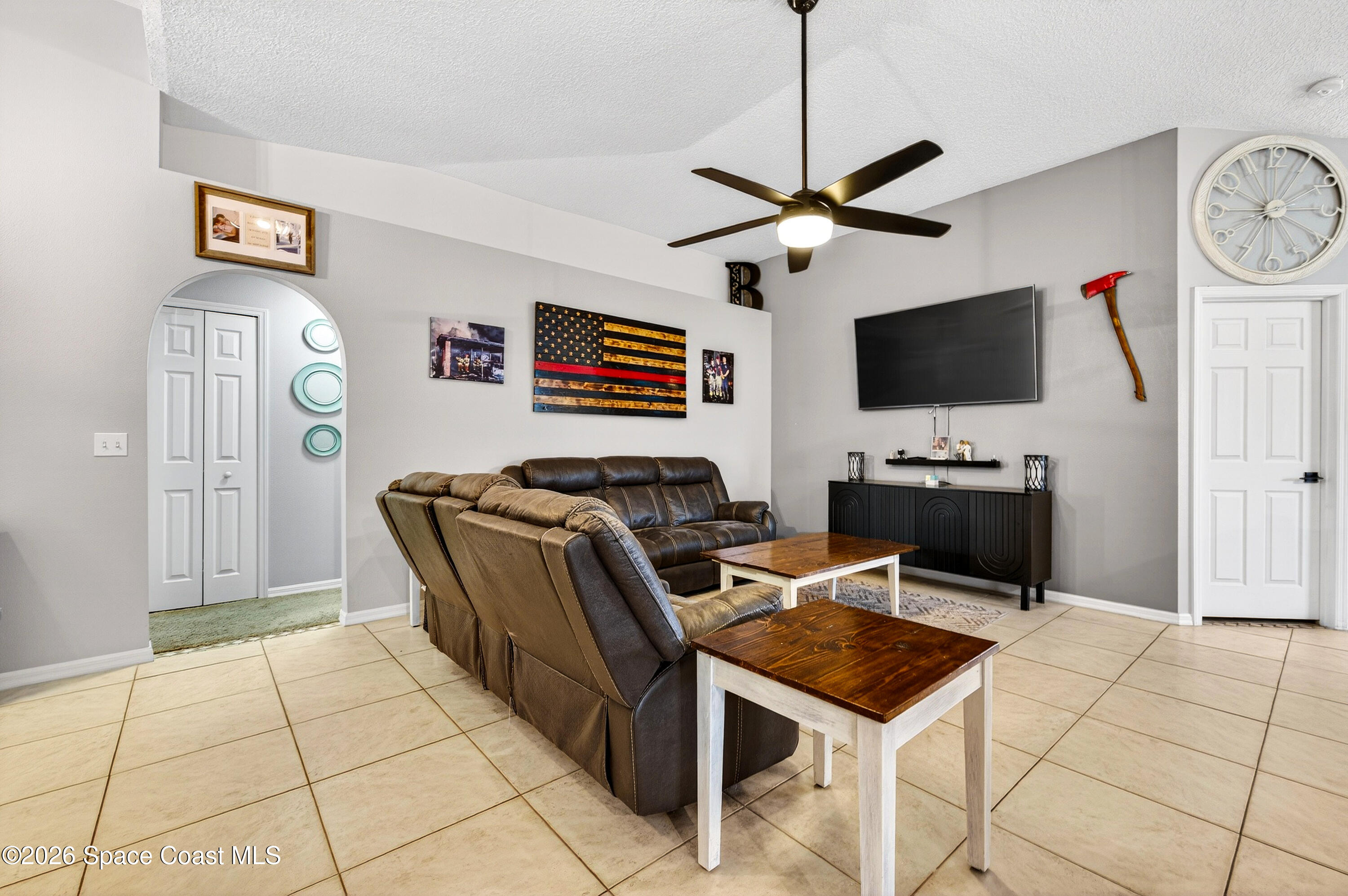 3393 Echo Ridge Place Cocoa, FL 32926 - Photo 13 of 40 a living room with furniture a flat screen tv and a table