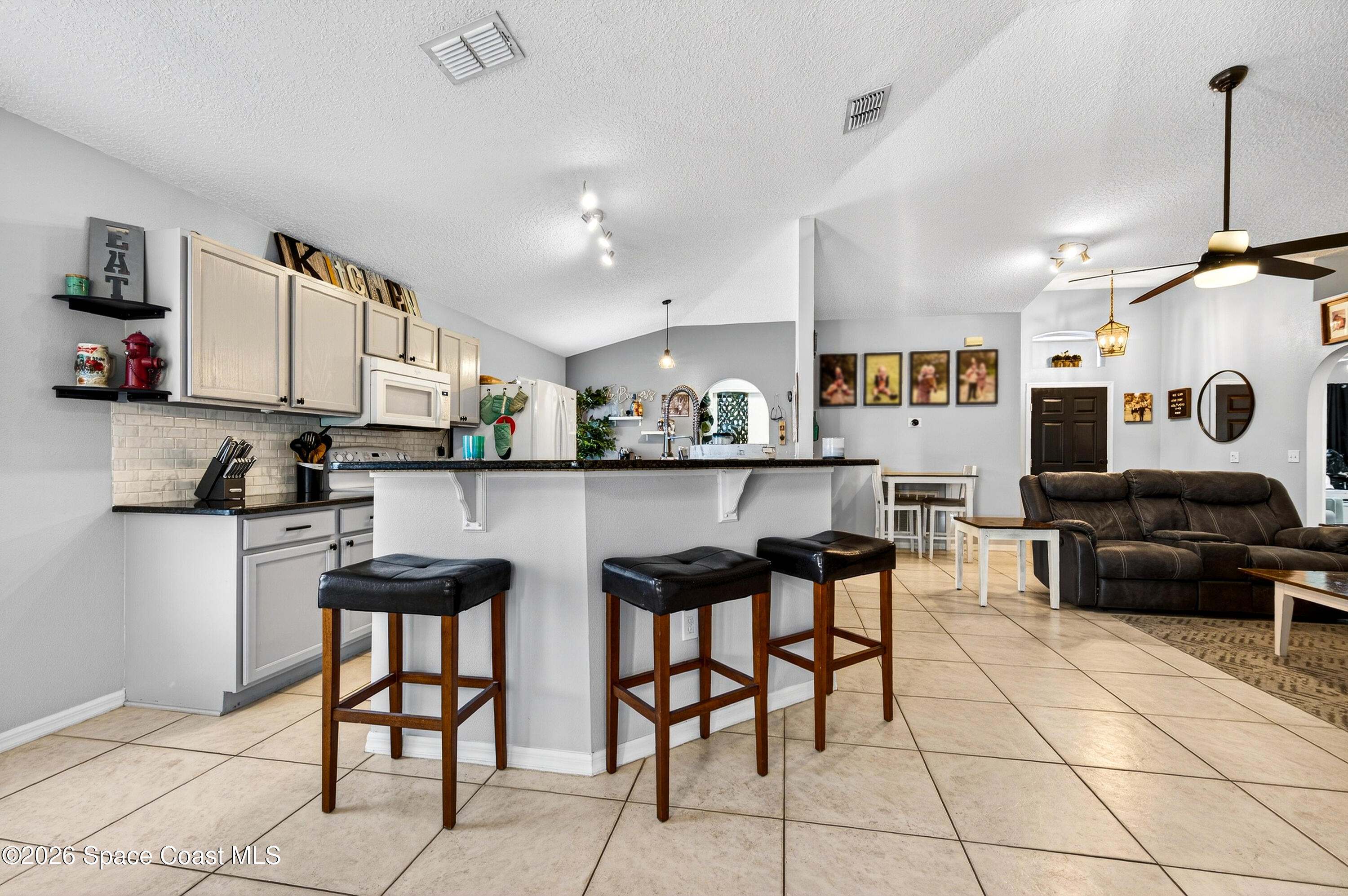 3393 Echo Ridge Place Cocoa, FL 32926 - Photo 23 of 40 a kitchen with stainless steel appliances kitchen island granite countertop a sink and cabinets