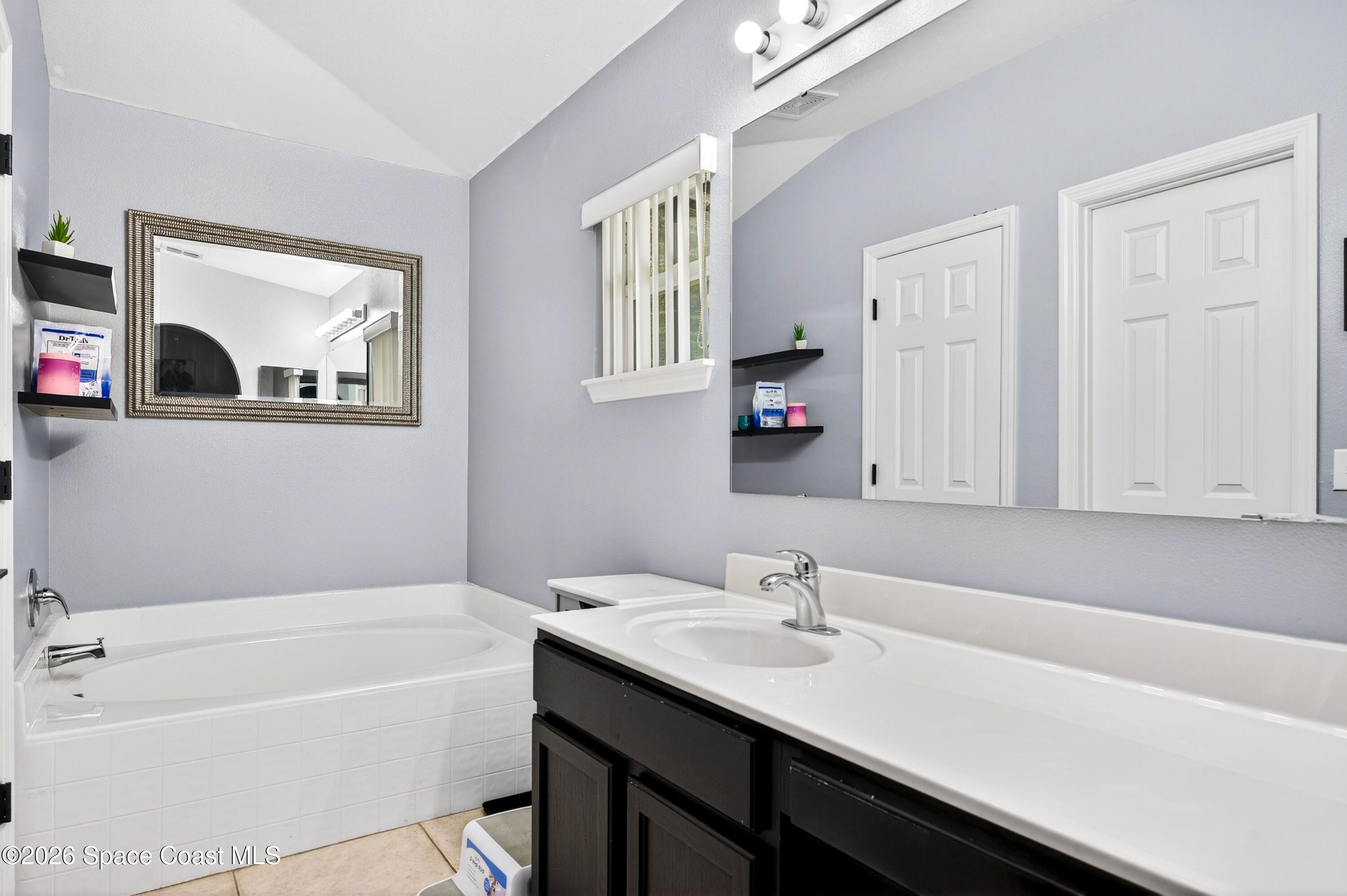 3393 Echo Ridge Place Cocoa, FL 32926 - Photo 27 of 40 a bathroom with a tub a sink and mirror