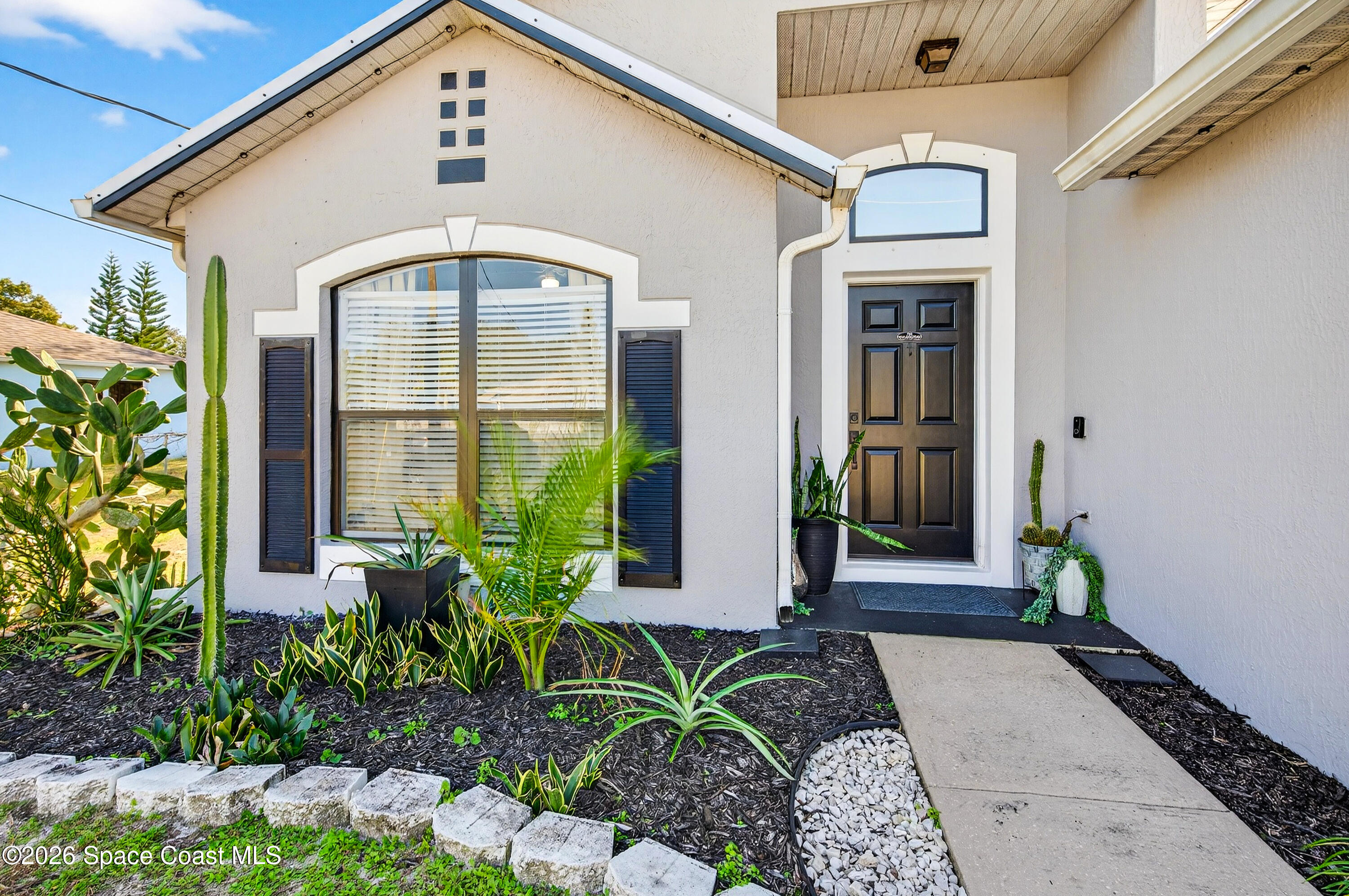 3393 Echo Ridge Place Cocoa, FL 32926 - Photo 5 of 40 a front view of a house with a garden