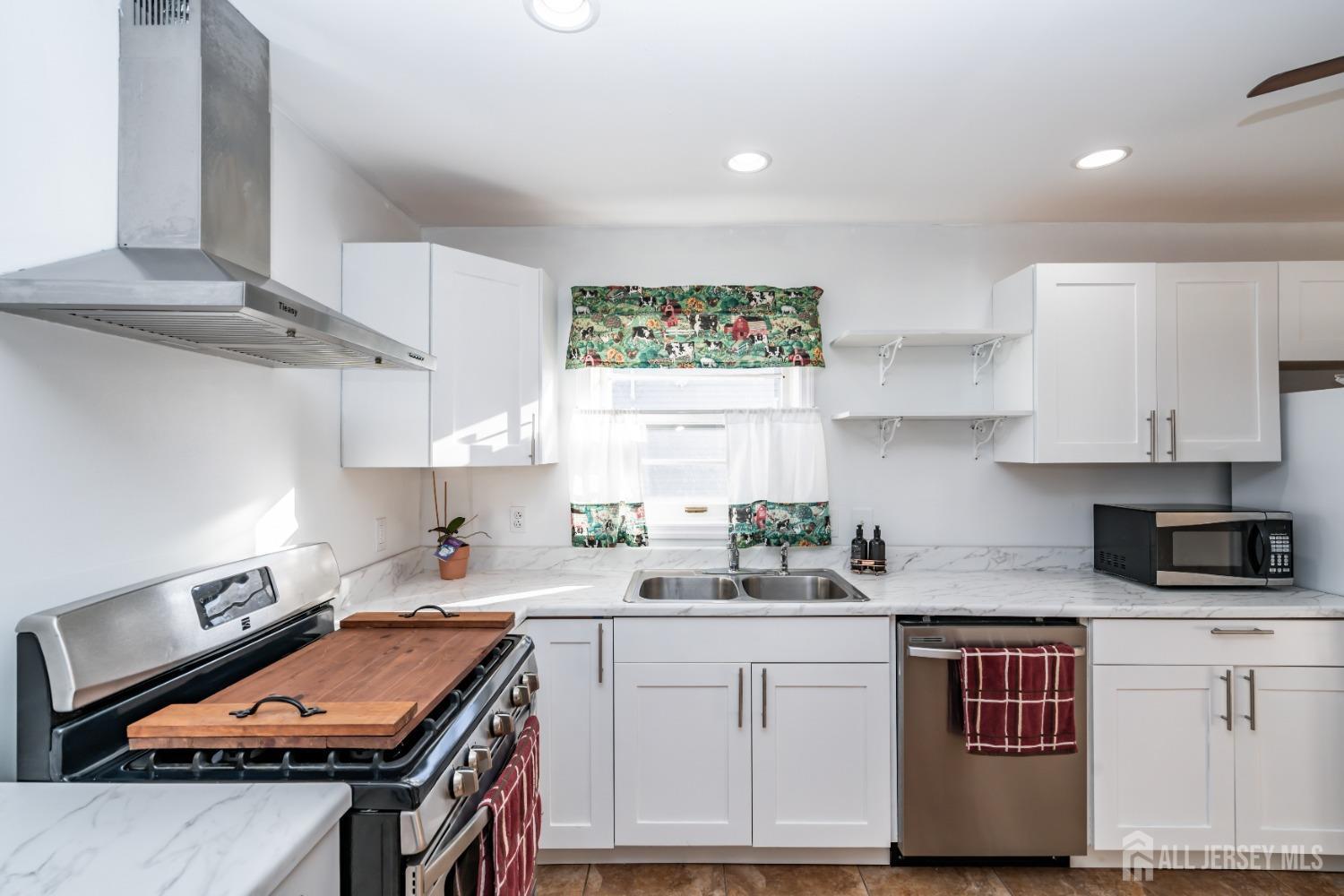11 Gurley Road Edison, NJ 08817 - Photo 5 of 24 a kitchen with stainless steel appliances granite countertop a stove a sink dishwasher and cabinets with wooden floor