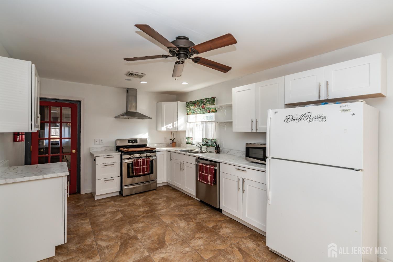 11 Gurley Road Edison, NJ 08817 - Photo 6 of 24 a kitchen with a stove a refrigerator and white cabinets