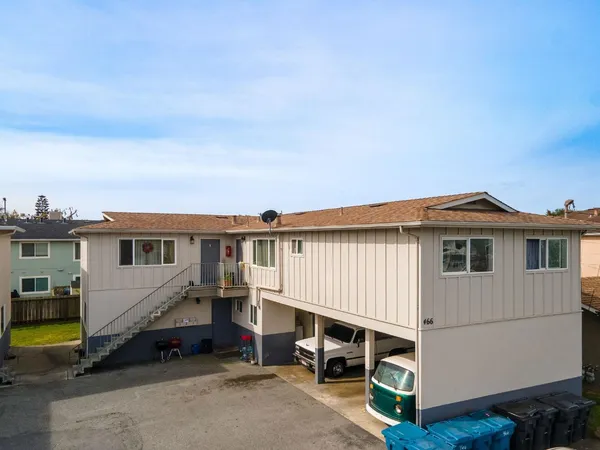 a view of a house with backyard and sitting area