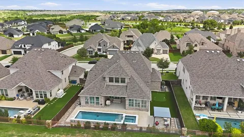 an aerial view of multiple houses with a big yard