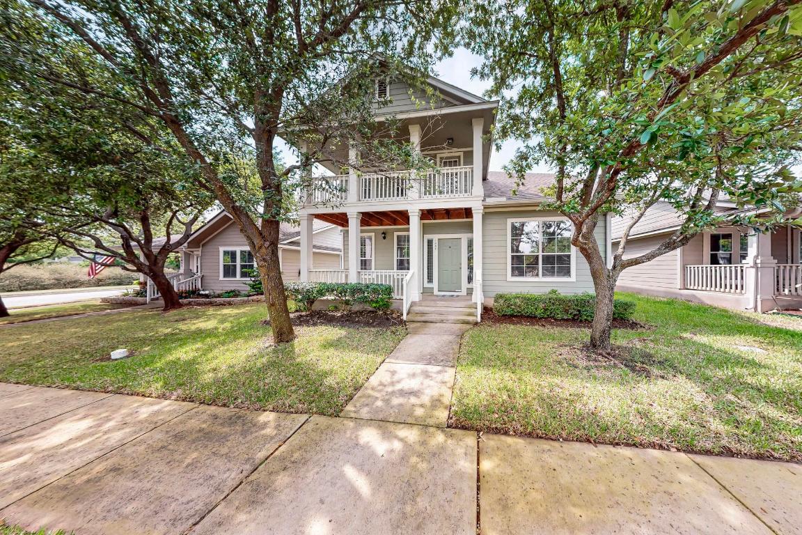 a front view of a house with a garden and trees
