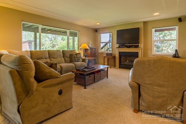 22522 Rickard Road Bend, OR 97702 - Photo 12 of 23 a living room with furniture a large window and a flat screen tv