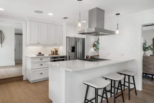 a kitchen with granite countertop white cabinets white appliances and a window