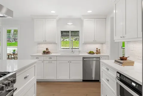 a kitchen with granite countertop a sink stainless steel appliances and cabinets