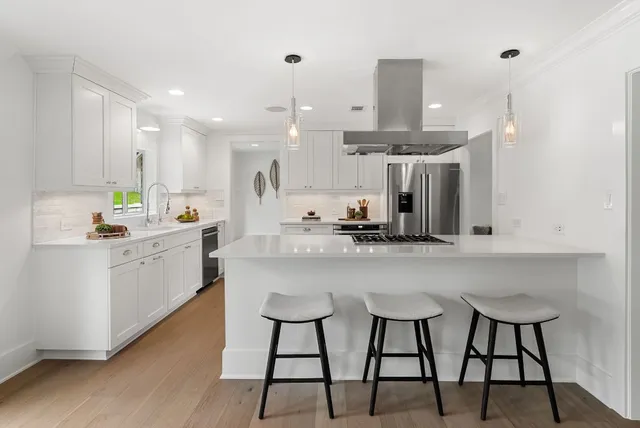 a kitchen with stainless steel appliances kitchen island a refrigerator and a stove top oven