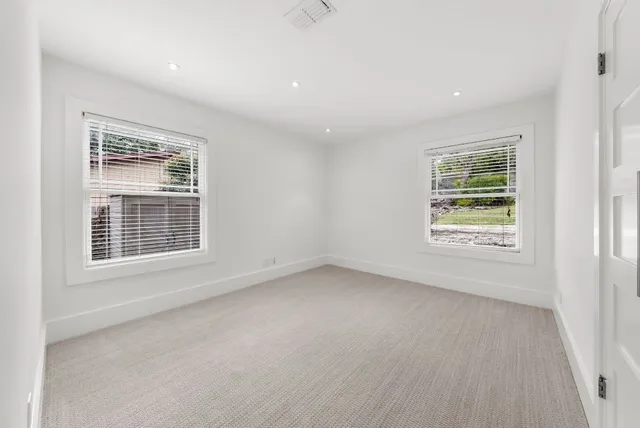 a bathroom with a double vanity sink toilet and a mirror