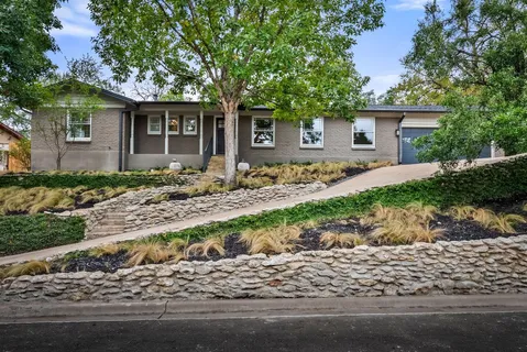 front view of a house with a yard and potted plants