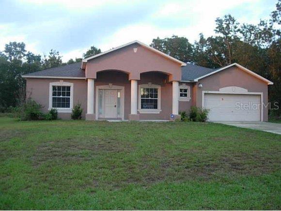 4525 Southwest 145th Place Road Ocala, FL 34473 - Photo 1 of 1 a front view of a house with a yard and garage