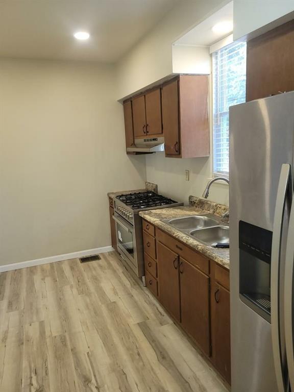 411 Fair Oaks Street McKees Rocks, PA 15136 - Photo 3 of 23 a kitchen with stainless steel appliances granite countertop a refrigerator a stove and a sink with wooden floor