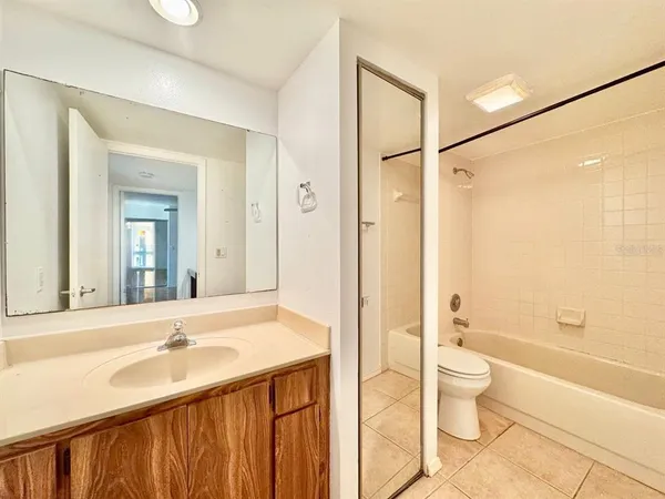 a bathroom with a bathtub shower sink mirror and toilet
