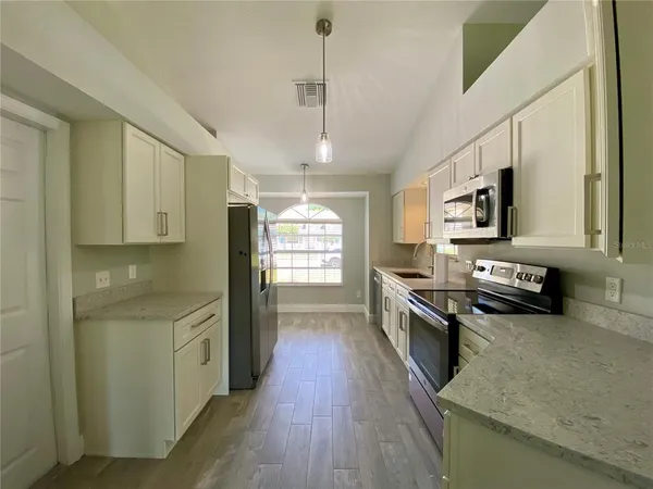 a kitchen with stainless steel appliances granite countertop a stove a sink and a refrigerator