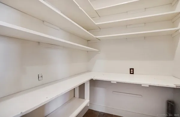 a view of cabinets and utility room with racks on the wall