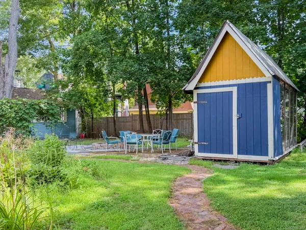 a view of backyard with table and chairs and wooden fence
