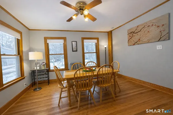 a dining room with furniture a chandelier and wooden floor