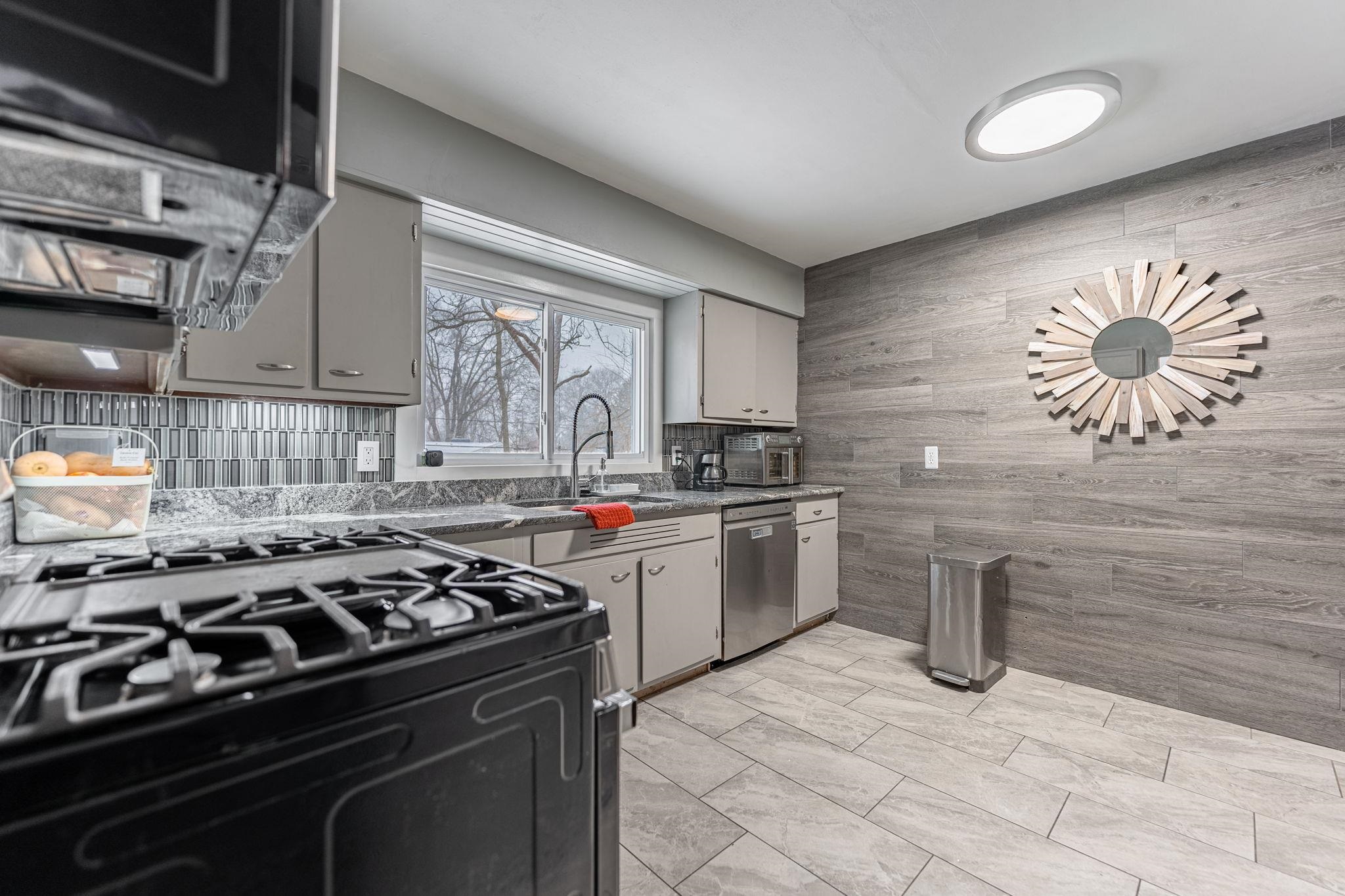 1924 North Alpine Road Rockford, IL 61107 - Photo 12 of 20 a kitchen with stainless steel appliances a stove a sink cabinets and a window