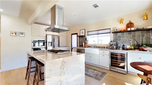 a kitchen with stainless steel appliances kitchen island granite countertop a stove and cabinets